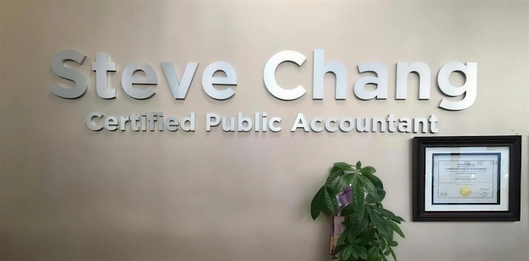 Reception wall at the office with the sign 'Steve Chang, Certified Public Accountant' and a framed certificate